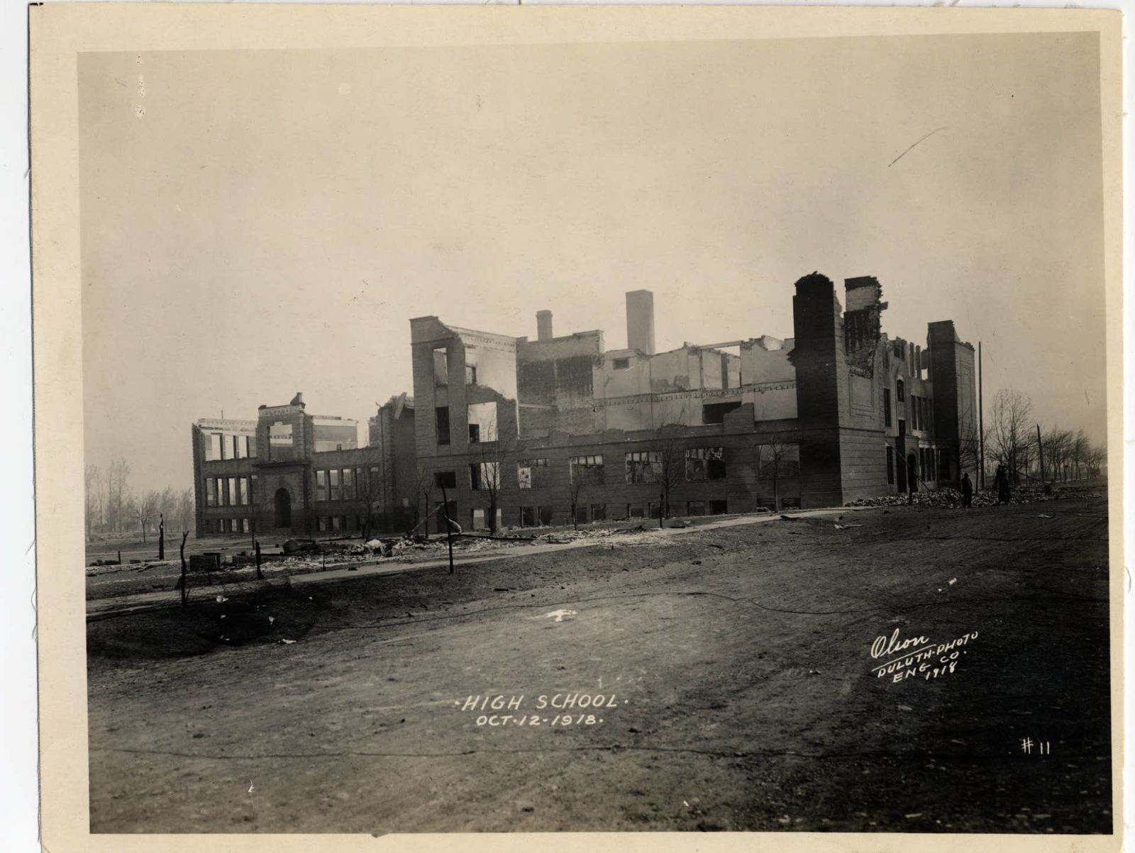 The roofless brick walls of Cloquet High School standing over burned ground